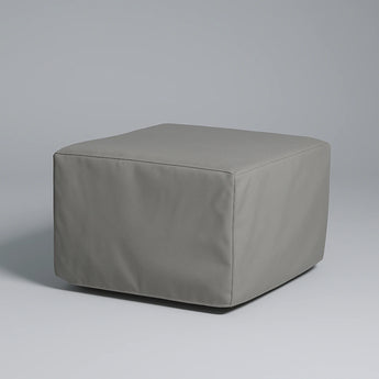 Gray cube-shaped ottoman on a gray background
