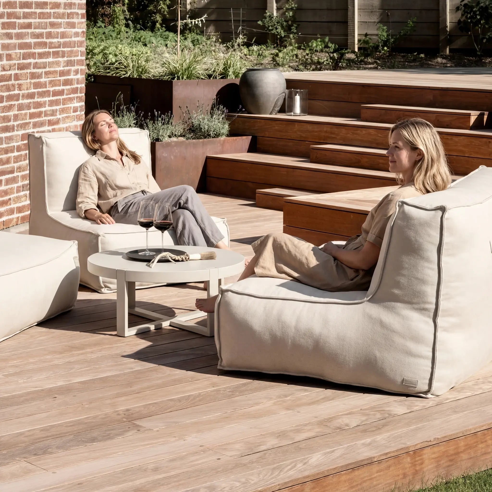Women relaxing on Troispommes outdoor lounge furniture on wooden deck